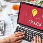 The laptop screen displays the word "TRACK" with a pin code